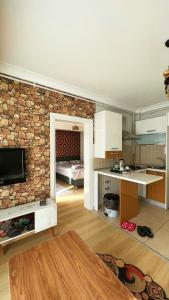 a living room with a stone wall and a kitchen at Edirne House in Edirne