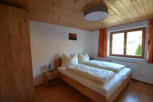 um quarto com uma cama grande e uma janela em Ferienwohnung Känzeleblick em Bezau
