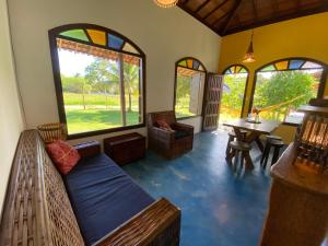 um quarto com um sofá, uma mesa e janelas em Cores do Mar Cabanas, Taipu de Fora em Barra Grande