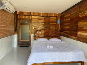 a bedroom with a bed with two white pillows at Floor river view in Cat Tien