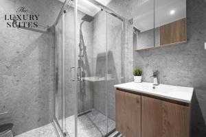 uma casa de banho com um chuveiro, um lavatório e um chuveiro em Bliss Apartments, The Luxury Suites em Tessalónica