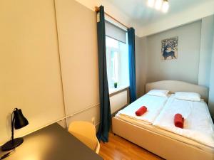 a bedroom with a bed with two red pillows on it at Gleznotaju Old Town Two Bedroom Apartment in Rīga