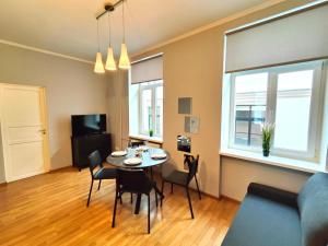 a living room with a table and chairs and a couch at Gleznotaju Old Town Two Bedroom Apartment in Rīga