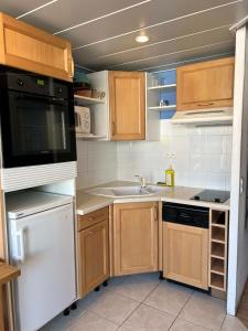 eine Küche mit weißen Geräten und Holzschränken in der Unterkunft Cosy and Lovely Unit in Val Thorens