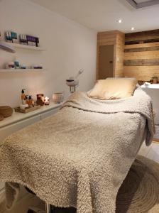 Un dormitorio con una cama con una manta. en Au Pré de Mukky, en Andenne