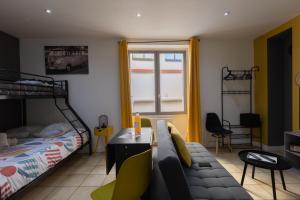 a bedroom with a couch and a bed and a window at L'appart K-psule - Design, tout confort, centre-ville, 3 pers in Le Mans