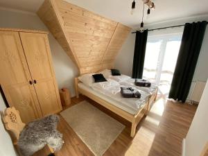 Schlafzimmer mit einem Bett mit Holzdecke in der Unterkunft Willa Pod Wyciągiem in Spytkowice
