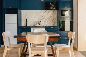 a kitchen with blue cabinets and a wooden table and chairs at Campanha Apartment By Porto Stories in Porto
