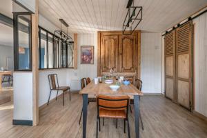 a dining room with a wooden table and chairs at Séjour pour 11 - Jardin - Arzon in Arzon +17 photos