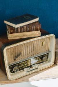 a stack of books sitting on top of an old radio at Campanha Apartment By Porto Stories in Porto