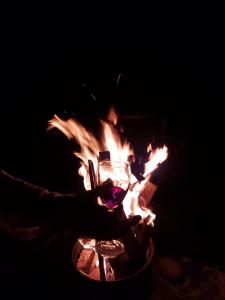 una persona sosteniendo una copa de vino frente al fuego en Hospedaje Campestre El Rancho de Jero en Jardin