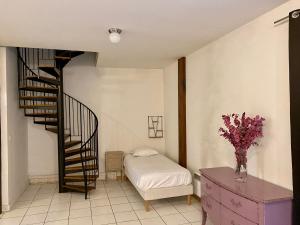 シャルトルにあるResidences De Chartresの螺旋階段とベッド付きのベッドルーム1室