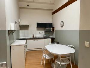 Il comprend une petite cuisine avec une table et des chaises blanches. dans l'établissement Residences De Chartres, à Chartres