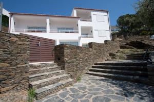 une maison blanche avec des escaliers en face d'un bâtiment dans l'établissement Aparthotel l'Heretat, à Cadaqués
