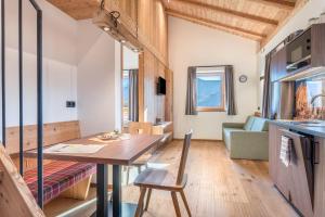 cocina y sala de estar con mesa y sofá en Guntschöllerhof Rotwand, en Fiè