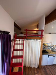 a loft bed in a kitchen with a ladder at Val Thorens Condo in Val Thorens