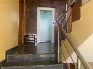 einen Flur mit einer Treppe, die zu einer Tür führt in der Unterkunft Sunil Residency in Coimbatore
