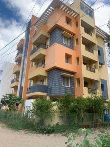 un grand bâtiment avec une clôture devant lui dans l'établissement Sunil Residency, à Coimbatore