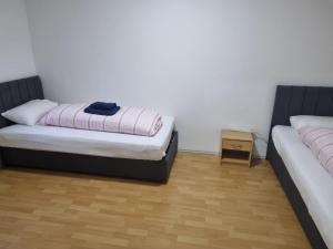 a bedroom with two beds and a wooden floor at Ferienwohnung Kassel Zentral in Kassel