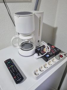 a coffee maker and a remote control on a table at Ferienwohnung Kassel Zentral in Kassel