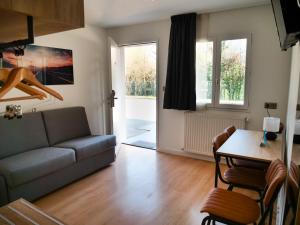 een woonkamer met een bank en een tafel bij Motel 991 in Viviers-du-Lac