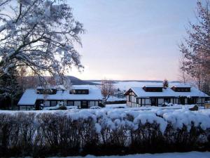 a house covered in snow in front of a yard at Feriendorf Öfingen - Urlaub im Schwarzwald in Bad Dürrheim