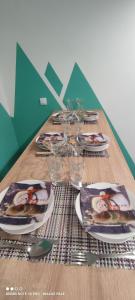 a long wooden table with plates and glasses on it at KovacInalux Apartmani in Pale