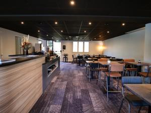 un restaurante con mesas y sillas y un bar en Motel 991 en Viviers-du-Lac