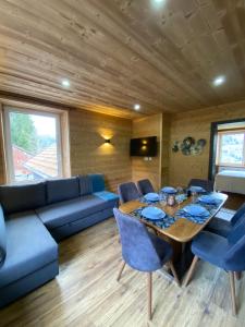 ein Wohnzimmer mit einem blauen Sofa und einem Tisch in der Unterkunft Les Chalets Bambi & Jacuzzi privatif in La Bresse