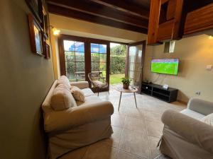 a living room with a couch and a flat screen tv at Complejo la Regalina in Cadavedo