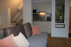 ein Wohnzimmer mit einem Sofa und einer Küche in der Unterkunft Appartement Kopp am Kirnberg See in Unterbränd