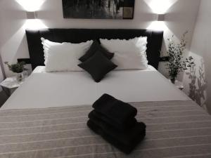 1 dormitorio con 1 cama blanca y 2 almohadas negras en Apartment in Duce with sea view, terrace, air conditioning, WiFi 3423-6 en Duće