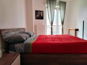 1 dormitorio con 1 cama con manta roja en IEO -Humanitas - SUNNY HOUSE - Comodissimo, en Locate di Triulzi