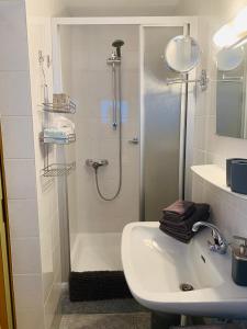 baño blanco con ducha y lavamanos en Haus Lawerz, en Nauders