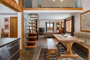 uma cozinha e sala de estar com uma mesa de madeira em Chalet 4BR Wood Stove , Home Cinema , Parental Suite em Les Houches