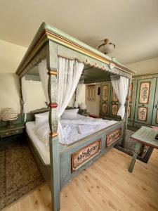 a bedroom with a canopy bed with white pillows at Landhaus-Chalet-Keilberger Blick in Kurort Oberwiesenthal