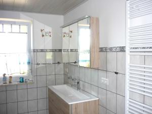 ein weißes Badezimmer mit einem Waschbecken und einem Spiegel in der Unterkunft Petersen Uwe in Großenwiehe