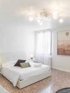 ヴェネツィアにあるPenthouse Dream Apartments by Wonderful Italyの白いベッドルーム(ベッド1台、天井ファン付)