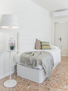 ヴェネツィアにあるPenthouse Dream Apartments by Wonderful Italyの白いベッドルーム(白いベッド1台、ランプ付)