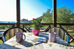 a table with a vase of flowers on a porch at Holiday house in Drage with sea view, balcony, air conditioning,W-LAN 571-1 in Drage
