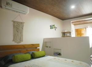 a bedroom with a bed with green pillows at Apartamentos y Studios Brisas del Mar Santa Teresa in Santa Teresa Beach