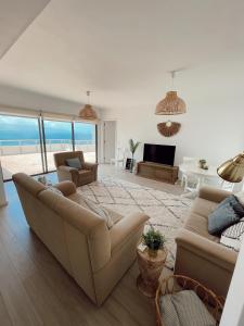 salon z kanapą i salon z widokiem na ocean w obiekcie Monte Azul Penthouse w mieście Ribeira Grande