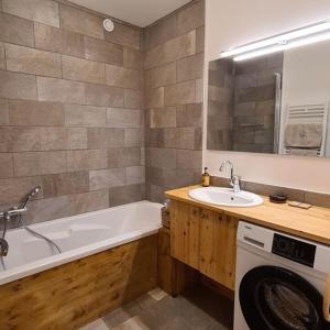een badkamer met een wastafel en een wasmachine bij Les Suites du Monetier, alliant le charme et l'authenticité d'un chalet de prestige au cœur du village in Le Monêtier-les-Bains