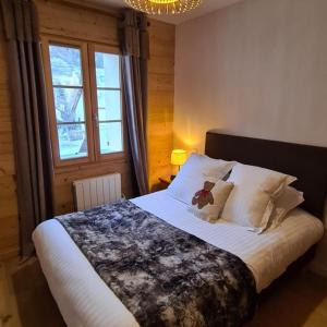 Un pat sau paturi într-o cameră la Les Suites du Monetier, alliant le charme et l'authenticité d'un chalet de prestige au cœur du village