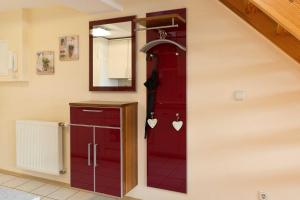 uma porta vermelha numa cozinha com um espelho em Kietzspeicher App 39 em Waren