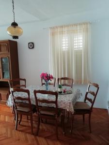 een eettafel met stoelen en een vaas met bloemen erop bij Apartment in Pisak with sea view, balcony, air conditioning, WiFi 195-1 in Pisak