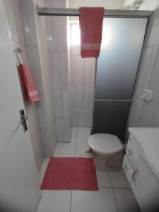 baño con aseo y alfombra roja en Ap aconchegante e climatizado ótima localização, en Foz do Iguaçu