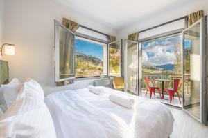 a bedroom with a white bed and a table and chairs at Snowglory Boutique Hotel in Arachova