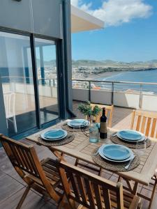 a table on a balcony with a view of the ocean at Monte Azul Penthouse in Ribeira Grande