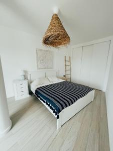 Un dormitorio con una cama con una manta de rayas blancas y negras. en Monte Azul Penthouse, en Ribeira Grande